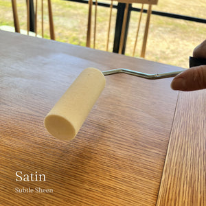 
                      
                        Person using a roller to apply satin finish to wooden furniture.
                      
                    