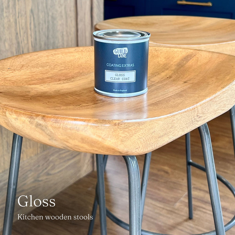 Can of Guild Lane paint on a wooden table with 'Gloss Maximum Shine' text.