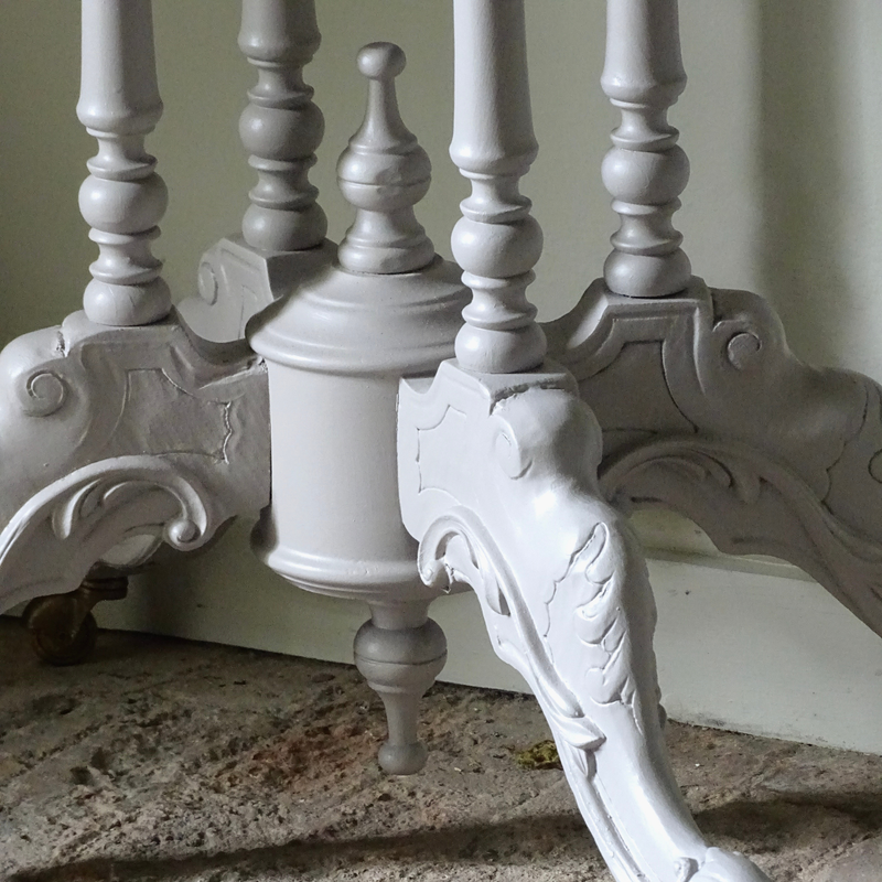 Close-up of ornate grey table on a vintage brick floor