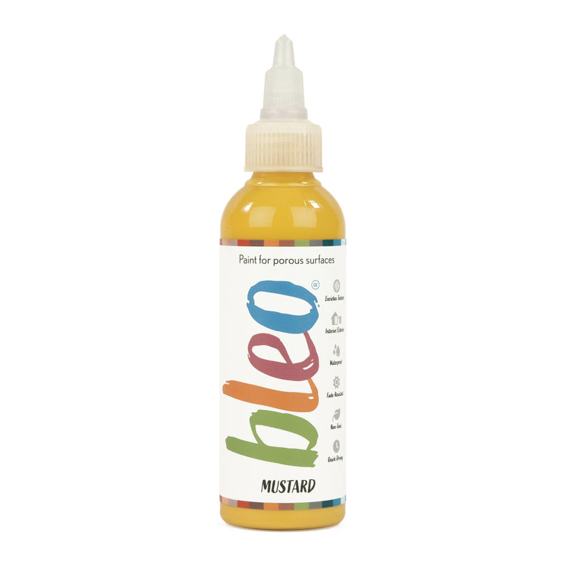 A bottle containing coloured gel paint, on a white background of bleo mustard