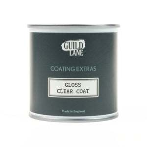 
                      
                        A bottle of Guild Lane gloss top coat with the label clear coat indicated as gloss finish for coating extras, made in England.
                      
                    
