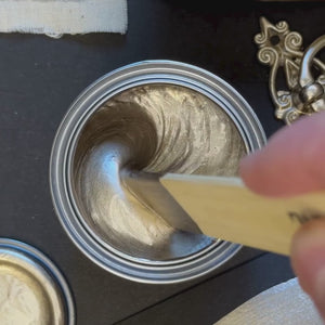 
                      
                        Load and play video in Gallery viewer, A wooden spatula stirs a thick, cool-toned platinum metallic paint. The paint is then swatched onto a black background with a brush, showing exceptional opacity and a crisp, white-gold metallic brilliance.
                      
                    